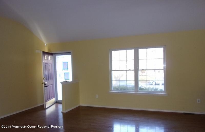 121 Brigantine Road Manahawkin, NJ 08050 - Photo 2 of 4 a view of an empty room with wooden floor and a window