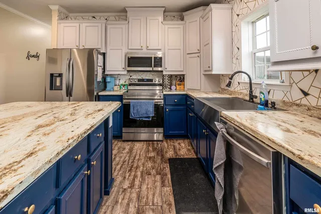 a kitchen with stainless steel appliances granite countertop a sink stove refrigerator and cabinets