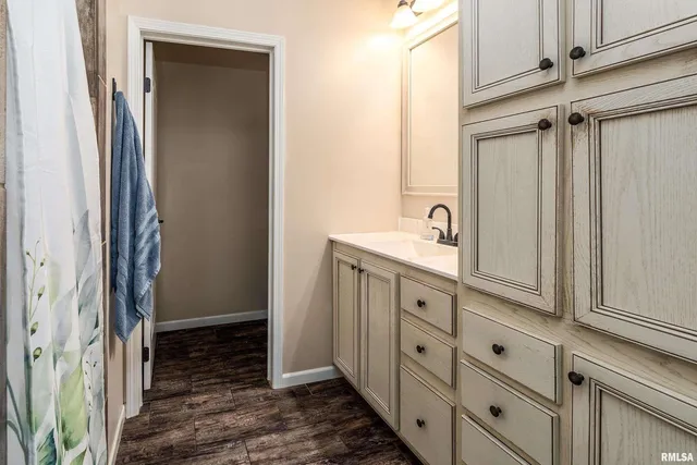 a bathroom with a granite countertop sink and a mirror