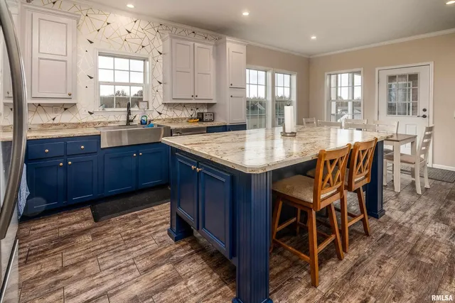 a kitchen with granite countertop wooden cabinets dining table and chairs