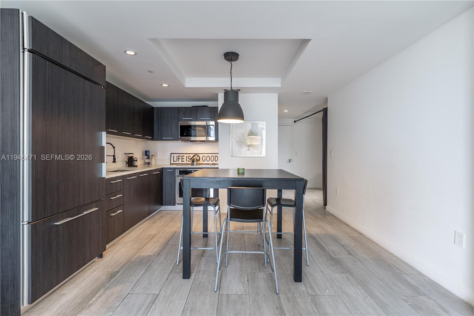 45 Southwest 9th Street, Unit 1205 Miami, FL 33130 - Photo 11 of 27 a kitchen with kitchen island granite countertop a sink a counter space stainless steel appliances and cabinets