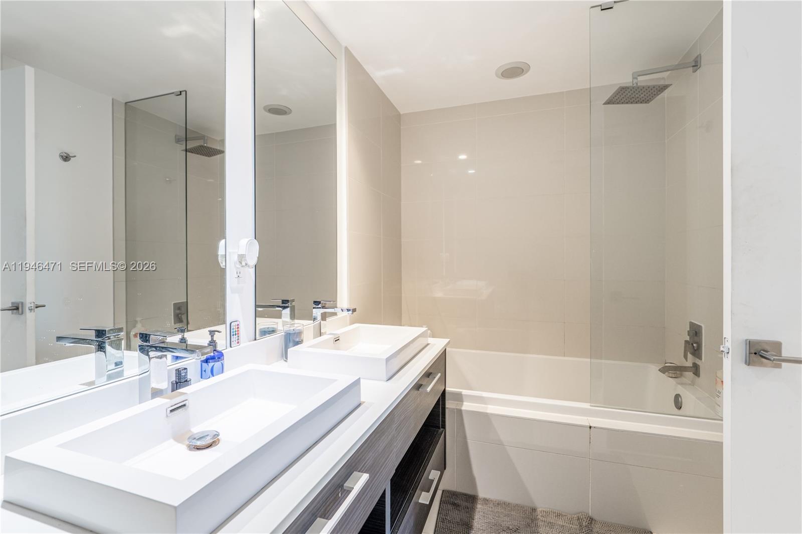 45 Southwest 9th Street, Unit 1205 Miami, FL 33130 - Photo 18 of 27 a bathroom with a sink double vanity mirror and a bathtub