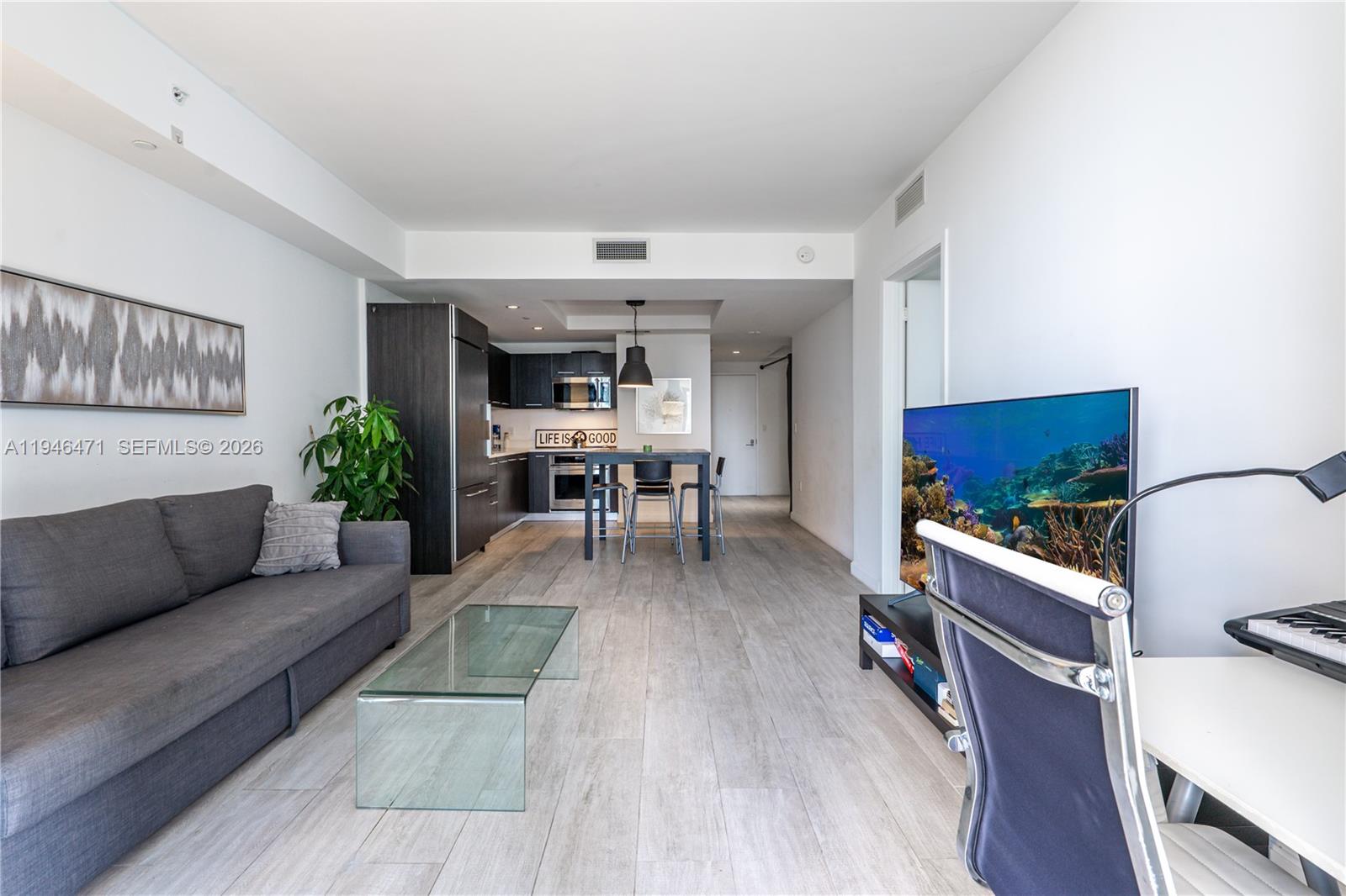 45 Southwest 9th Street, Unit 1205 Miami, FL 33130 - Photo 10 of 27 a living room with furniture and a wooden floor