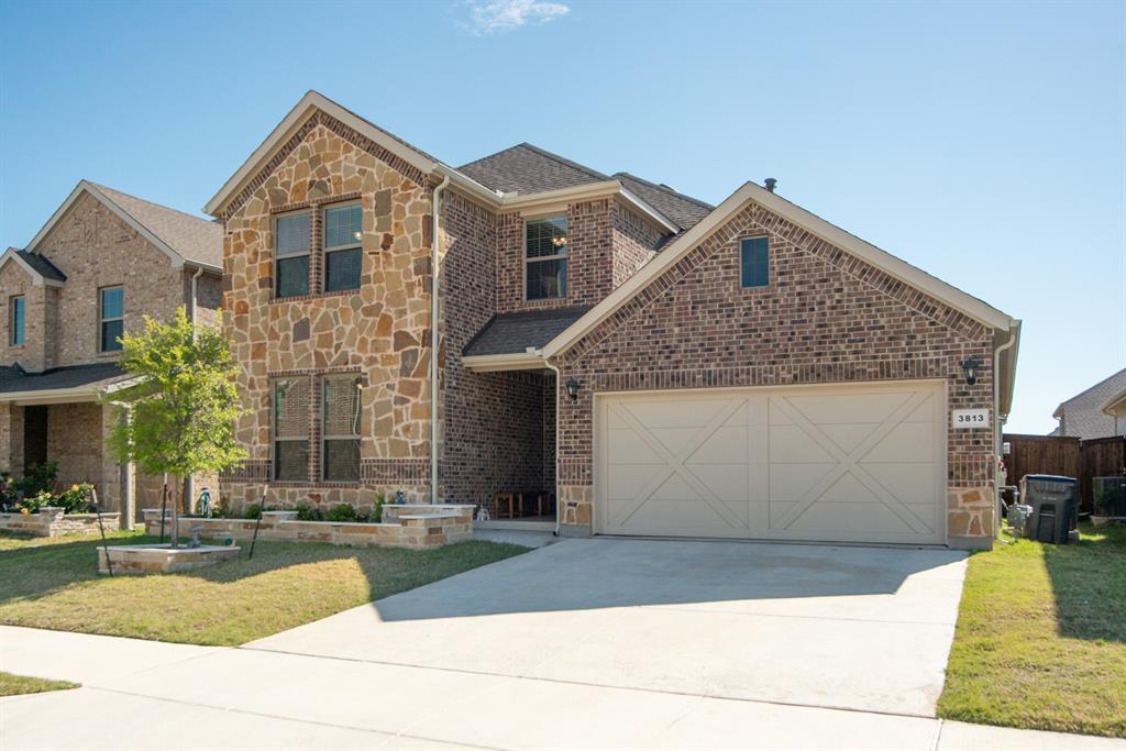 3813 Oldham Road Little Elm, TX 75068 - Photo 2 of 27 Traditional-style house with stone siding, concrete driveway, an attached garage, and brick siding