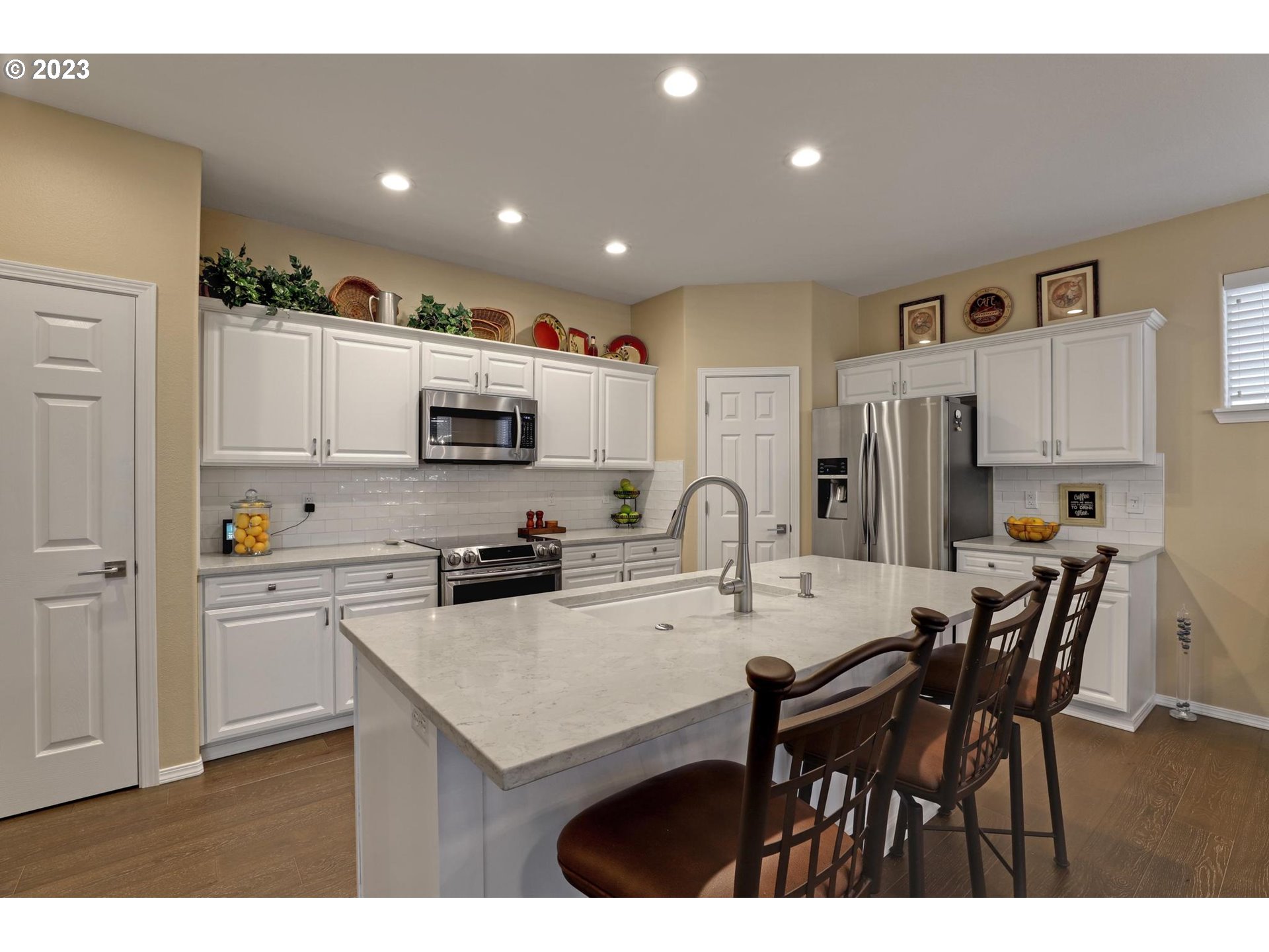 10698 Southwest Washington Street Portland, OR 97225 - Photo 12 of 25 a kitchen with stainless steel appliances a sink a stove a refrigerator cabinets and a dining table