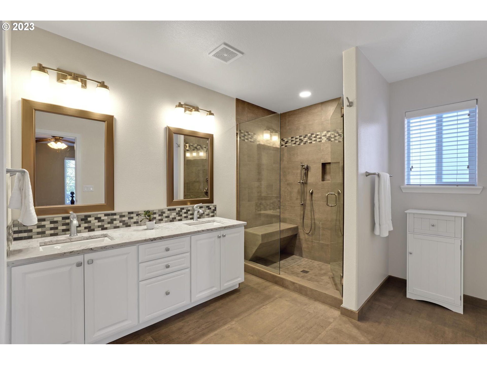 10698 Southwest Washington Street Portland, OR 97225 - Photo 17 of 25 a bathroom with a double vanity sink a toilet a mirror and shower