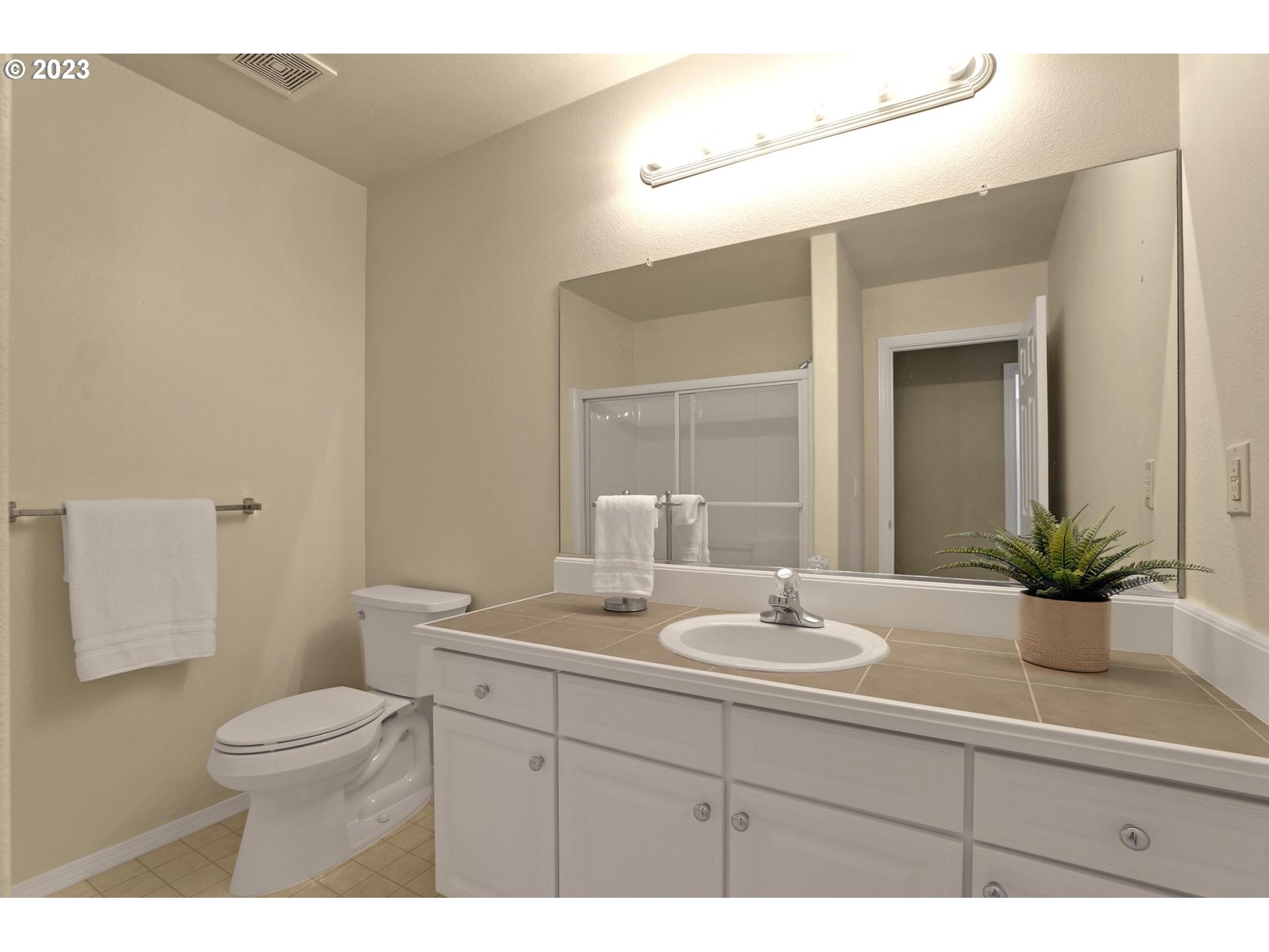 10698 Southwest Washington Street Portland, OR 97225 - Photo 21 of 25 a bathroom with a toilet a sink a large mirror and vanity