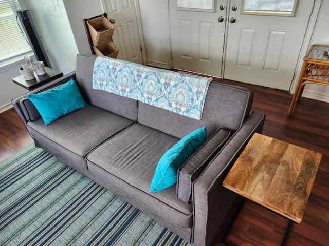 a living room with furniture a rug and a flat screen tv