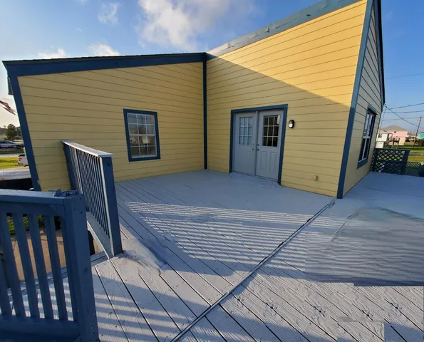 a view of backyard with deck and wooden floor