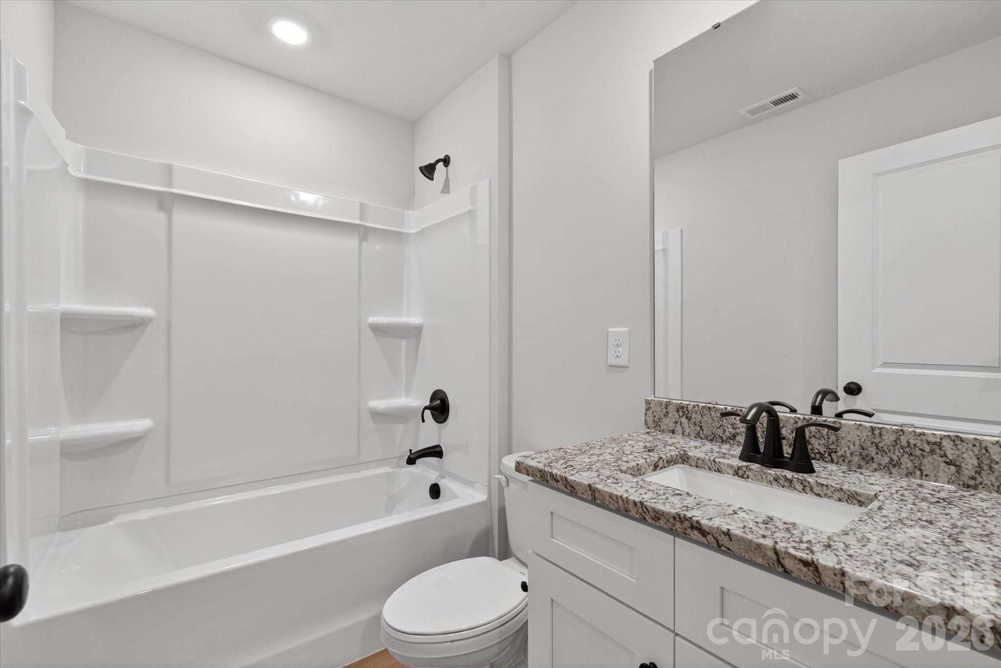 1850 Rhyne Elementary Drive Gastonia, NC 28052 - Photo 12 of 20 a bathroom with a granite countertop sink a toilet and bathtub