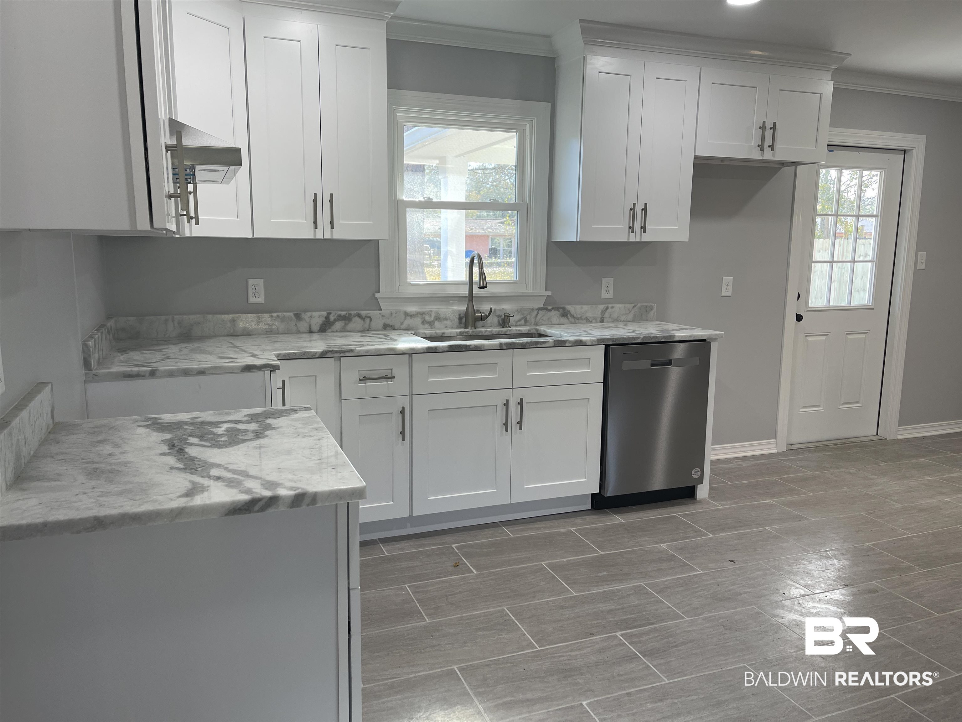 3901 Prima Vera Lane Mobile, AL 36605 - Photo 13 of 15 Kitchen with light stone counters, sink, stainless steel dishwasher, and white cabinets