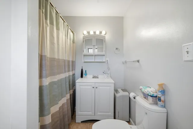 a bathroom with a sink a toilet and shower