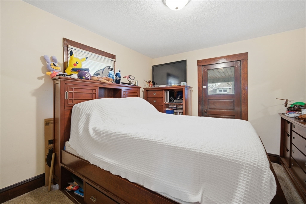 122 Hastings Street Springfield, MA 01104 - Photo 16 of 29 a bedroom with a bed and a chandelier