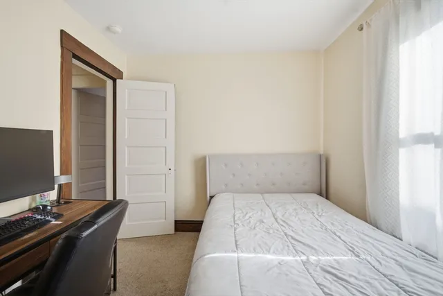 a bedroom with a bed and a computer on a desk