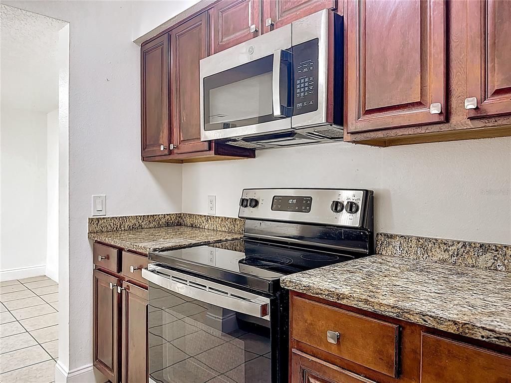185 Waterfall Way, Unit 102 Altamonte Springs, FL 32714 - Photo 21 of 59 a kitchen with stainless steel appliances granite countertop a stove and a microwave