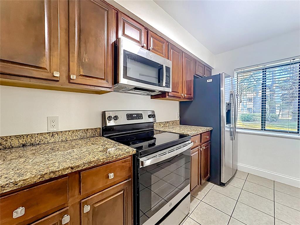 185 Waterfall Way, Unit 102 Altamonte Springs, FL 32714 - Photo 22 of 59 a kitchen with stainless steel appliances granite countertop a stove microwave and sink