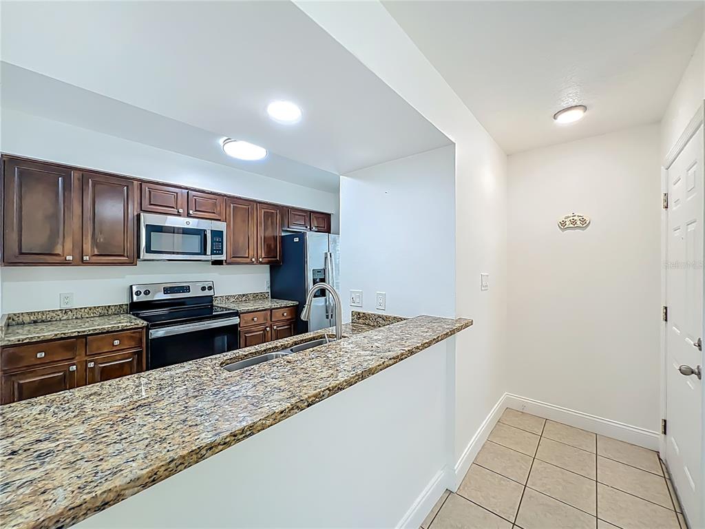 185 Waterfall Way, Unit 102 Altamonte Springs, FL 32714 - Photo 23 of 59 a kitchen with stainless steel appliances granite countertop a stove a sink and a microwave