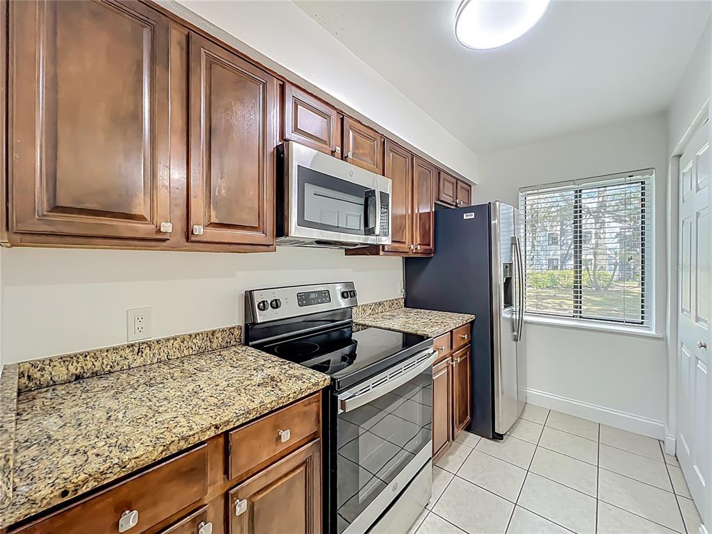 185 Waterfall Way, Unit 102 Altamonte Springs, FL 32714 - Photo 27 of 59 a kitchen with stainless steel appliances granite countertop a stove a sink and a microwave