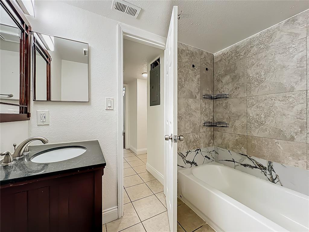 185 Waterfall Way, Unit 102 Altamonte Springs, FL 32714 - Photo 49 of 59 a bathroom with a sink a mirror a bathtub and shower