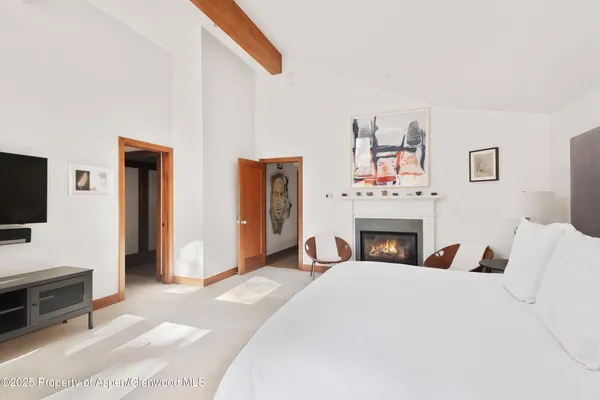 a bedroom with a large bed and large windows