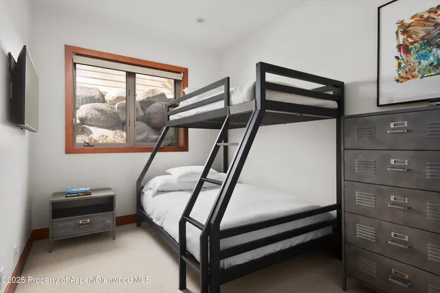 a bedroom with a bed and a painting on the wall