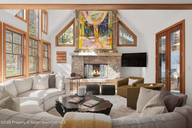 a living room with furniture a fireplace and a large window