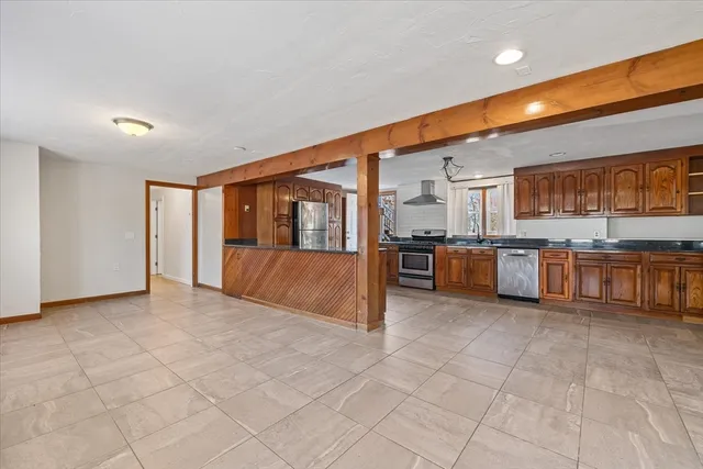 a large kitchen with stainless steel appliances granite countertop a stove and cabinets