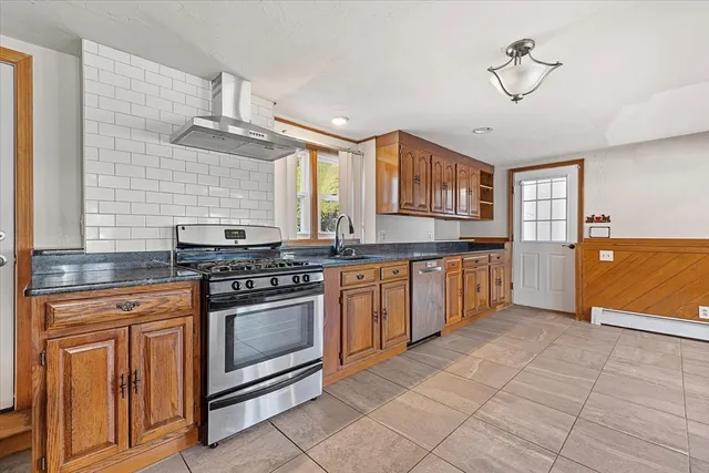 a kitchen with stainless steel appliances granite countertop a stove a sink and a refrigerator