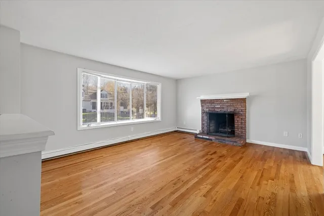 wooden floor fireplace and windows in an empty room