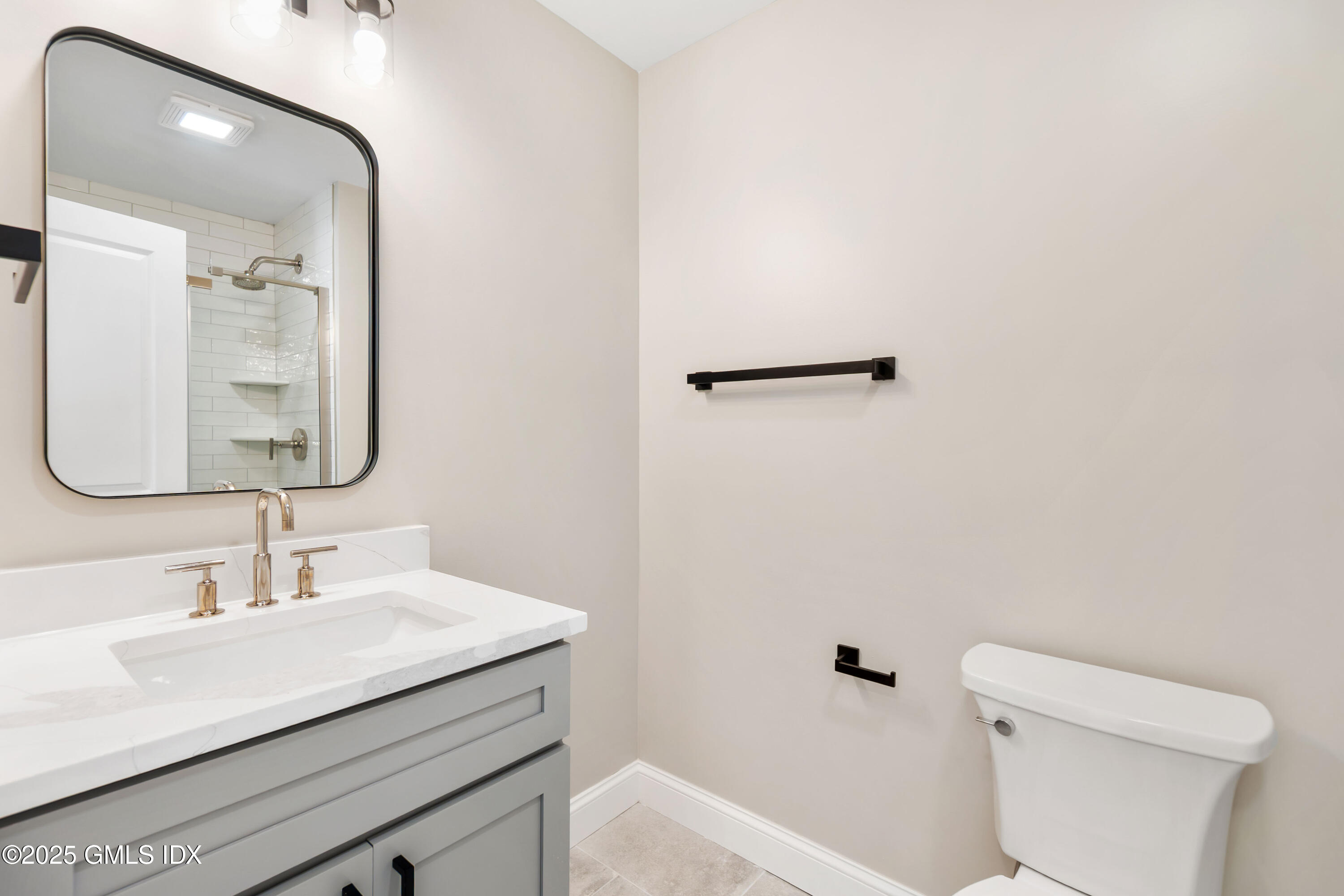 237 Weaver Street, Unit 8D Greenwich, CT 06831 - Photo 11 of 24 a bathroom with a sink a toilet and mirror