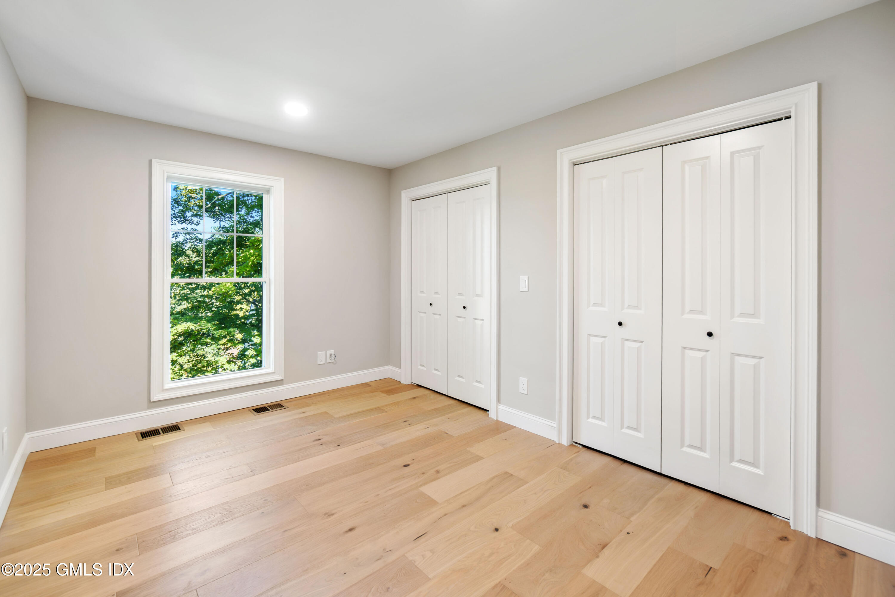 237 Weaver Street, Unit 8D Greenwich, CT 06831 - Photo 13 of 24 a view of an empty room with wooden floor and a window