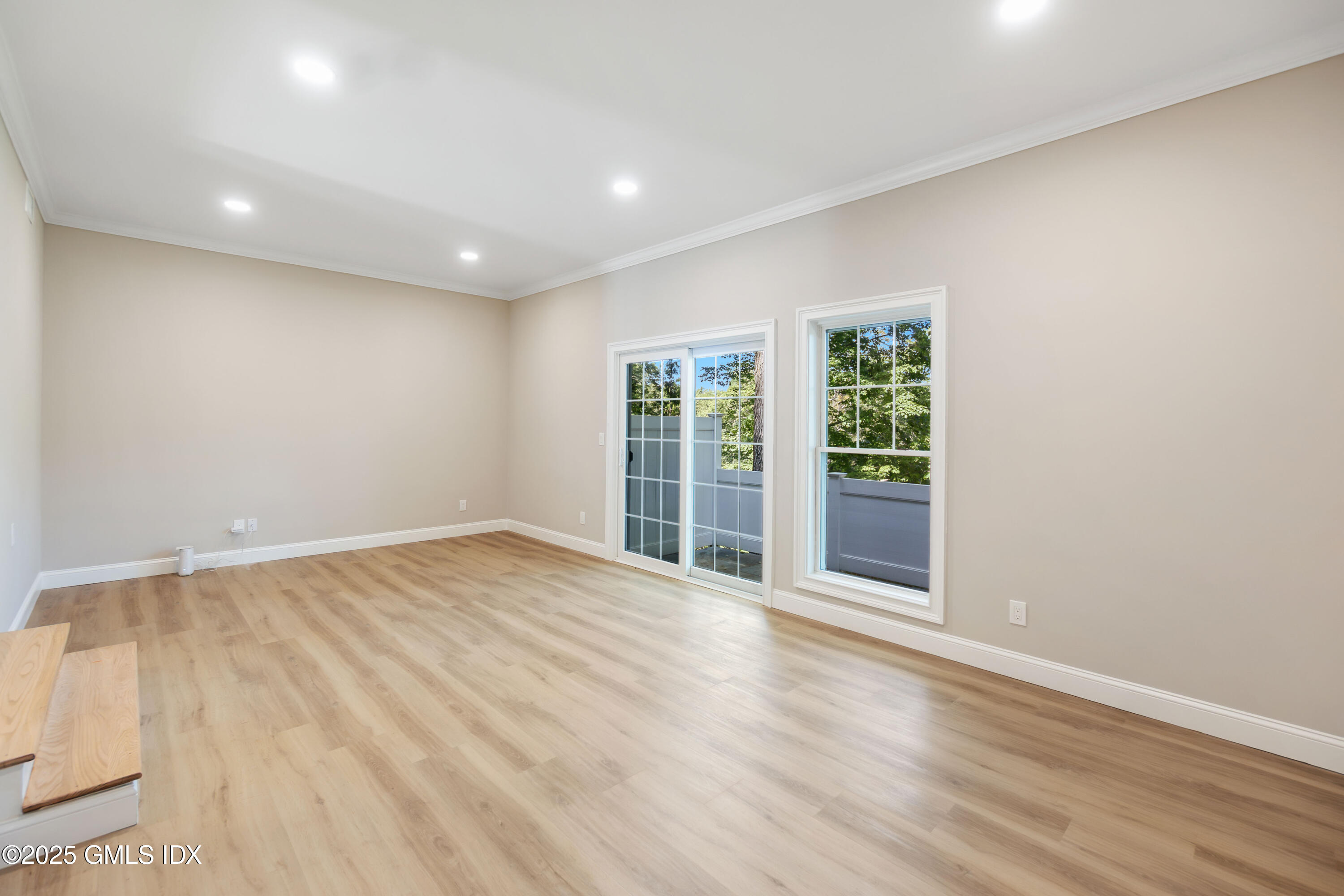 237 Weaver Street, Unit 8D Greenwich, CT 06831 - Photo 4 of 24 a view of an empty room with wooden floor and a window