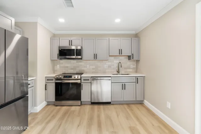 a kitchen with stainless steel appliances granite countertop a stove a sink and a refrigerator