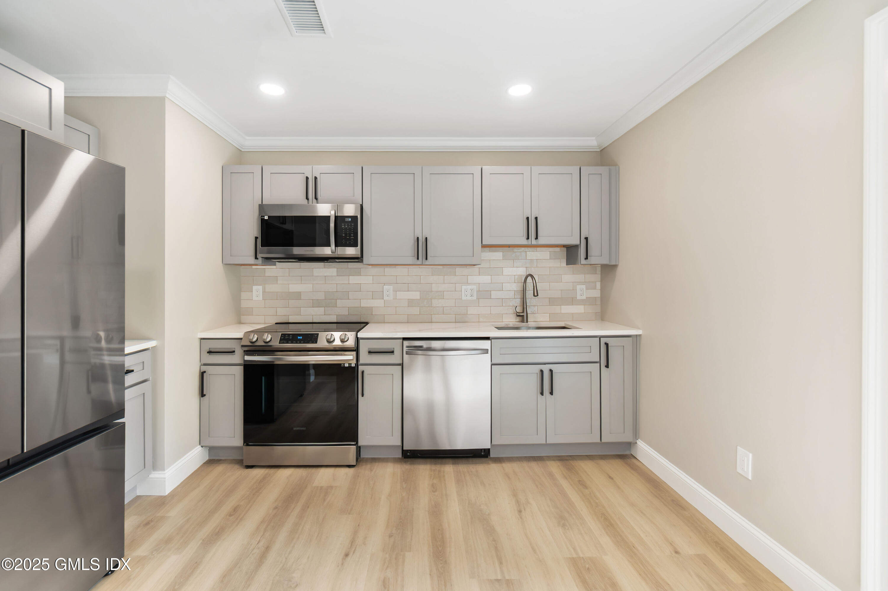 237 Weaver Street, Unit 8D Greenwich, CT 06831 - Photo 6 of 24 a kitchen with stainless steel appliances granite countertop a stove a sink and a refrigerator