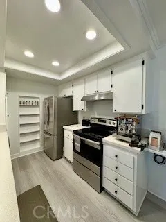 a kitchen with a stove and white cabinets