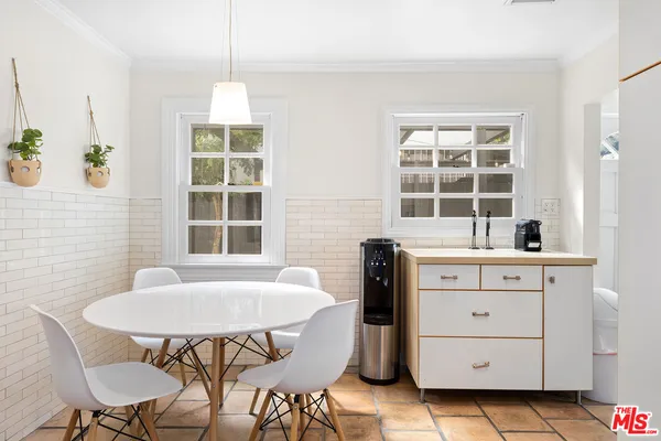 a kitchen with a table chairs and wooden cabinets