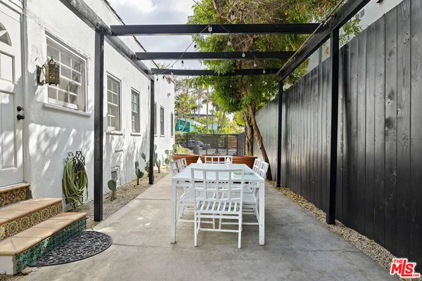 a view of patio with a table and chairs and floor to ceiling window with wooden floor