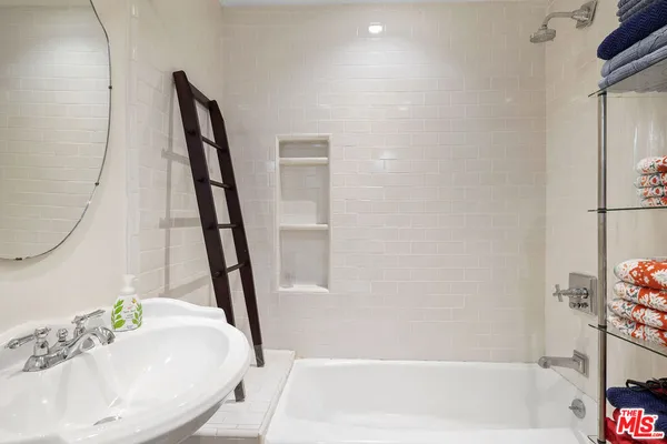 a bathroom with a tub sink and a mirror
