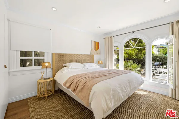 a bedroom with a bed and a large window