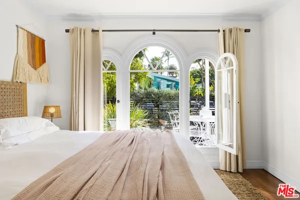 a bedroom with a bed and a large window