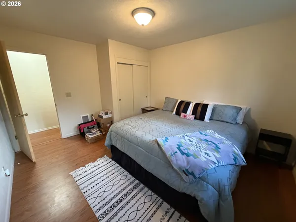 a bedroom with a bed and a flat tv screen on dresser