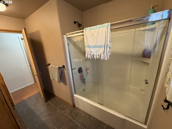 a bathroom with a glass door shower and a tub