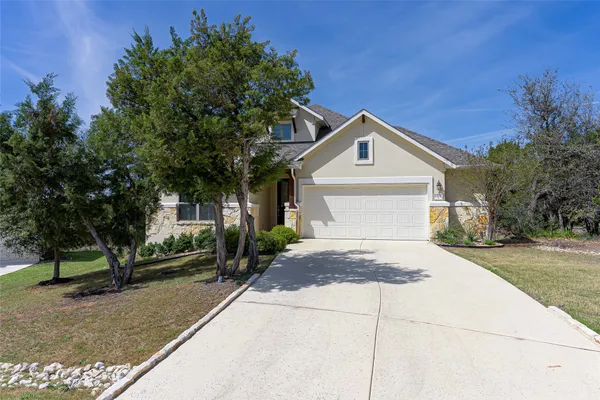 a front view of a house with a yard and trees