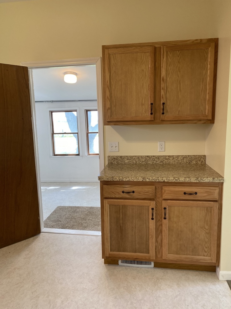 18240 Hurd Road Prophetstown, IL 61277 - Photo 4 of 18 a kitchen with granite countertop cabinets and black appliances