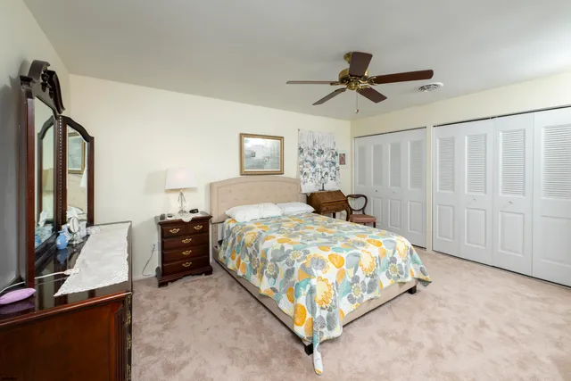 a bedroom with a bed a chandelier and dresser