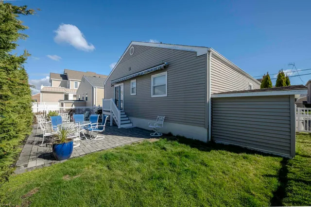a view of a patio with table and chairs with wooden fence and plants