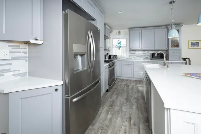 a kitchen with stainless steel appliances kitchen island granite countertop a stove and a refrigerator