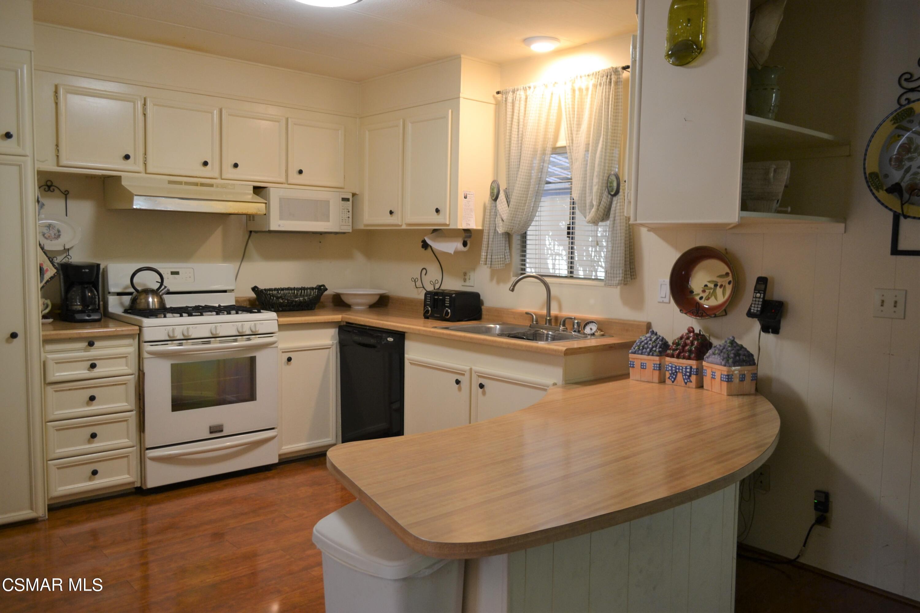 6480 Katherine Road, Unit 44 Simi Valley, CA 93063 - Photo 3 of 32 a kitchen with a sink a stove and cabinets