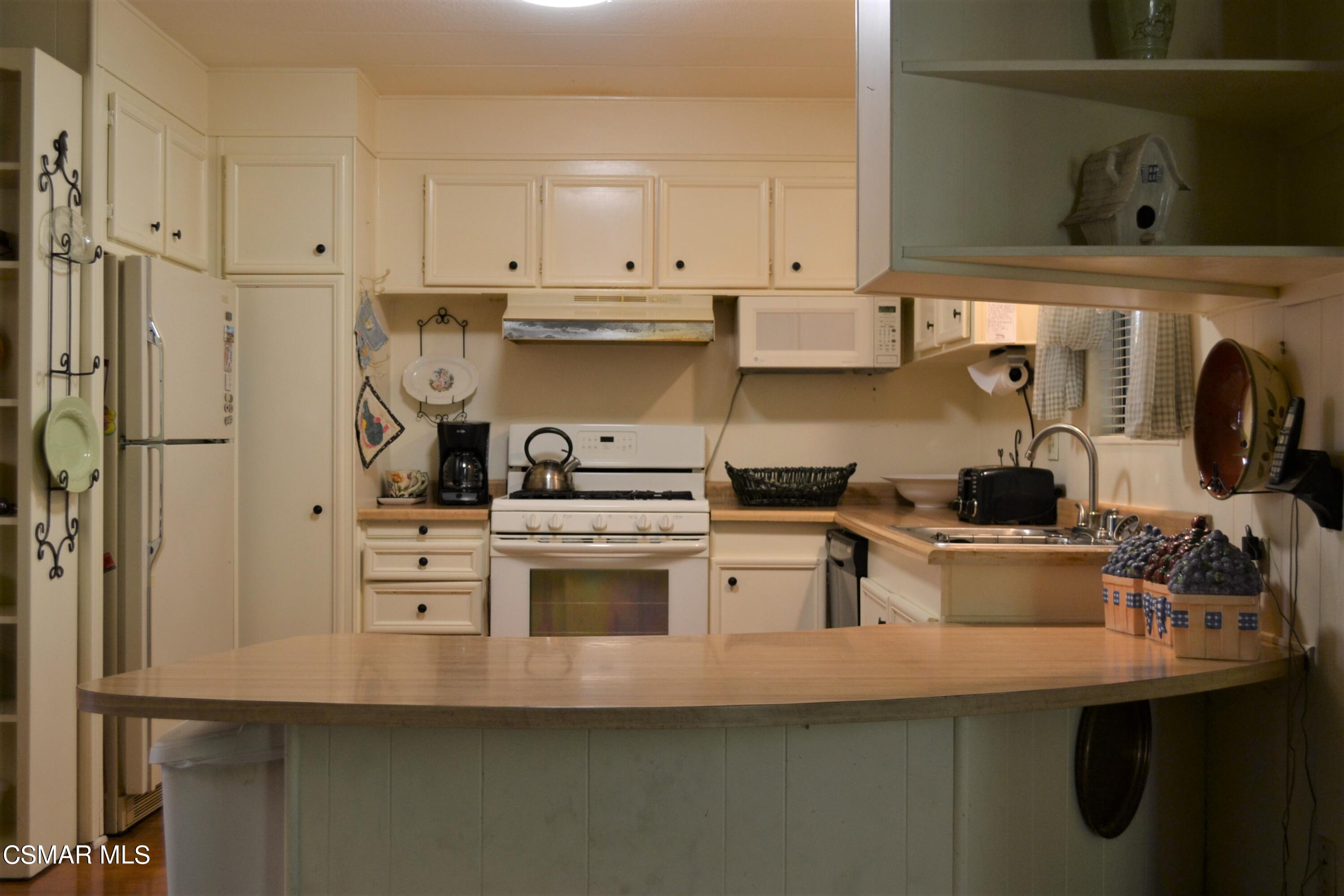 6480 Katherine Road, Unit 44 Simi Valley, CA 93063 - Photo 4 of 32 a kitchen with a sink a stove and cabinets