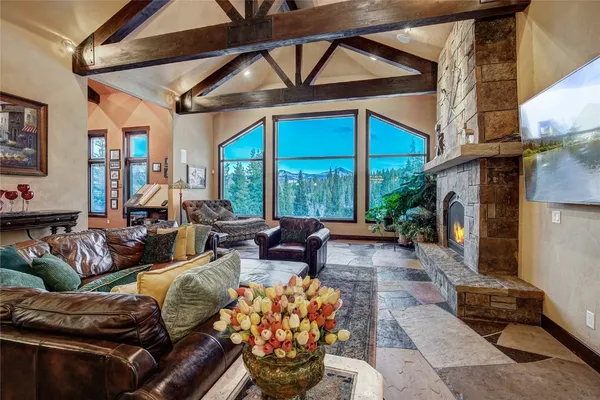 a living room with fireplace furniture and a large window